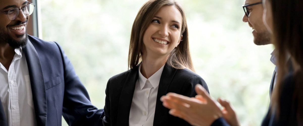 colleghi sorridenti discutono in ambiente lavorativo