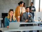 ragazza sorridente davanti al pc in un ufficio