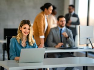 ragazza sorridente davanti al pc in un ufficio