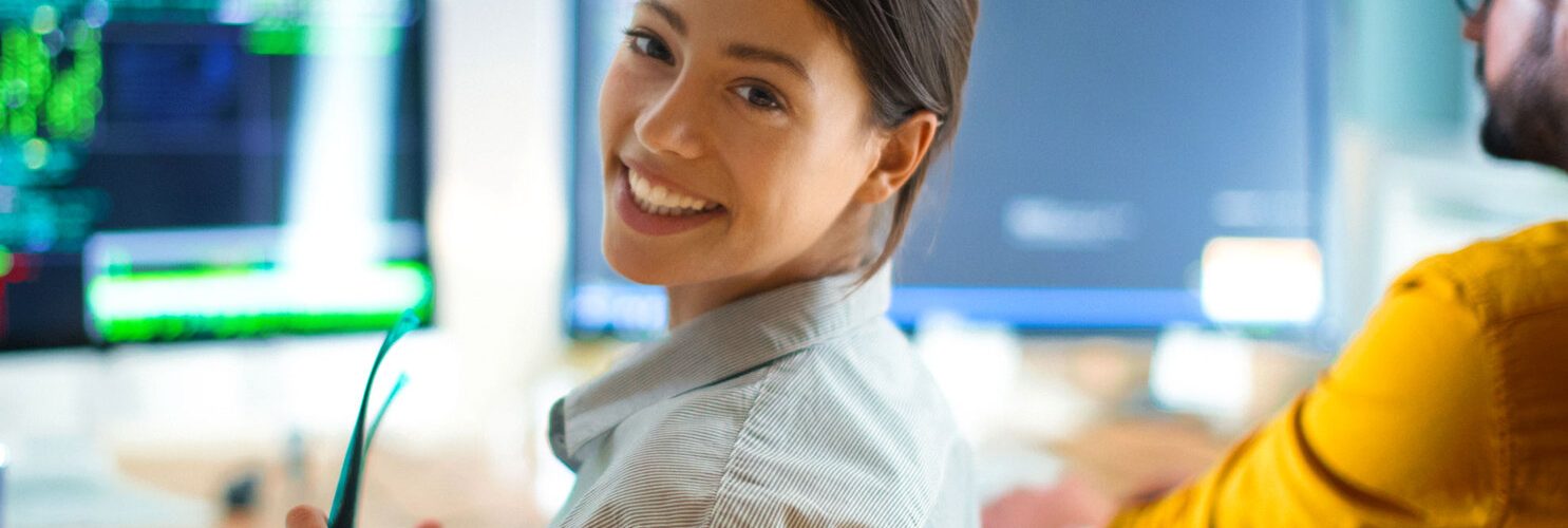 giovane ragazza sorridente seduta in postazione da ufficio