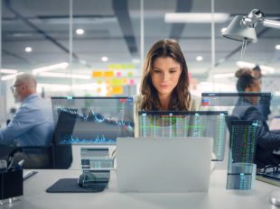 ragazza alla scrivania consulta grafici su schermo laptop